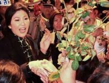 Thai Prime Minister Yingluck Shinawatra (L) receives flowers from her supporters as she arrives at the airport in Chiang Mai province. 11 December 2013